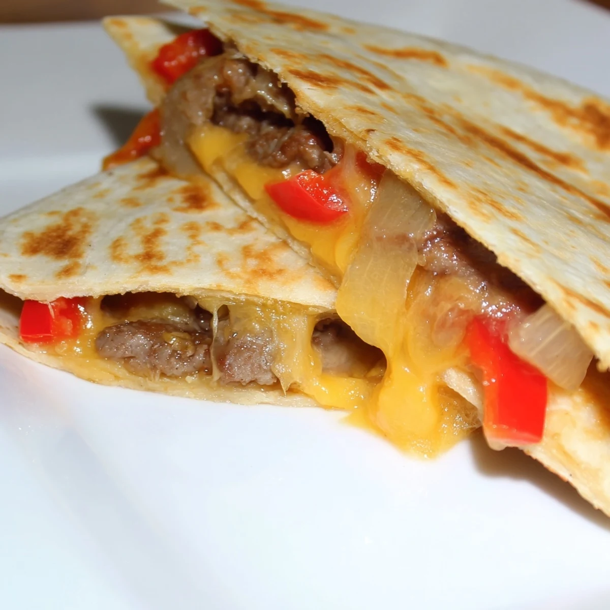 Golden-brown Beef Quesadillas with Salsa and Guacamole, cut into wedges on a rustic plate.