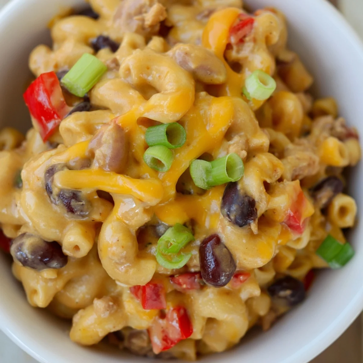A steaming bowl of Turkey Chili Mac and Cheese features tender elbow pasta coated in a rich, creamy cheddar sauce mixed with hearty ground turkey and beans.