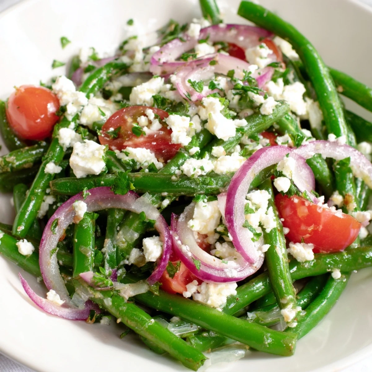 A close-up of the Green Bean Salad with Feta, showcasing crisp green beans, halved cherry tomatoes, and crumbled feta cheese tossed in a zesty lemon vinaigrette.