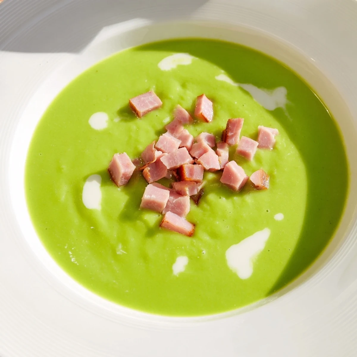 Creamy Spring Pea Soup with Turkey Ham served steaming hot in a rustic bowl with garnish.