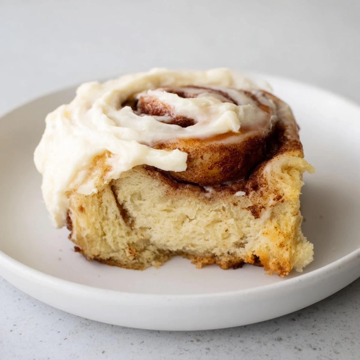 Freshly baked Keto Cinnamon Buns are stacked on a white plate, ready to be served for breakfast or snack.