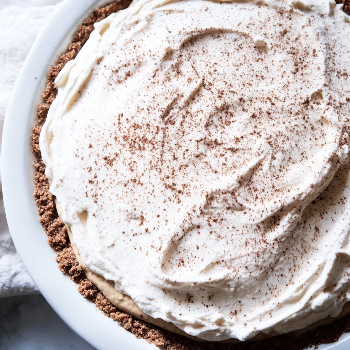 Enjoy a keto-friendly Keto Cold Brew Coffee Pie garnished with cocoa powder, perfect for summer gatherings or after-dinner treats.