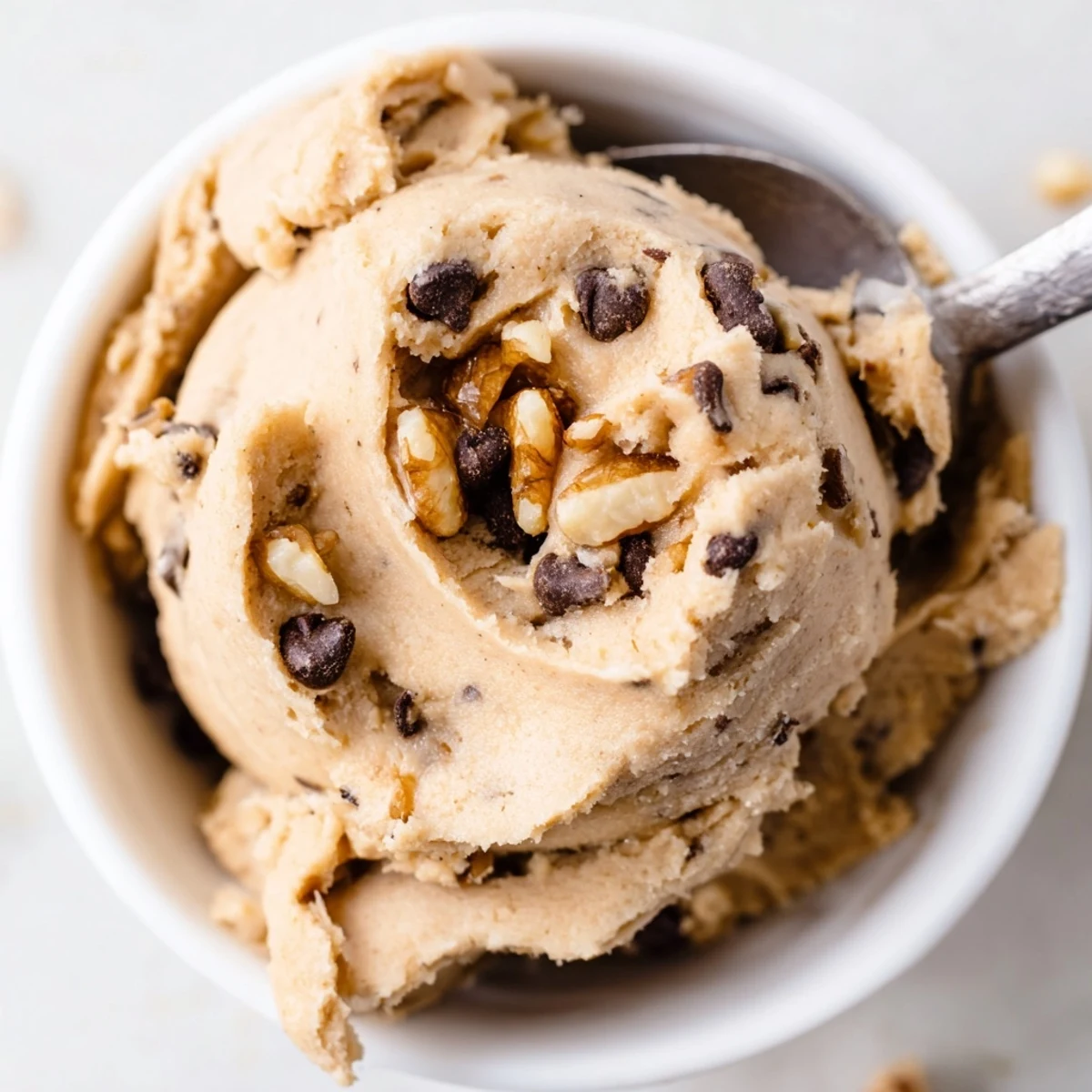 Close-up texture of Guilt Free Greek Yogurt Cookie Dough with swirls of peanut butter and mini chocolate chips.