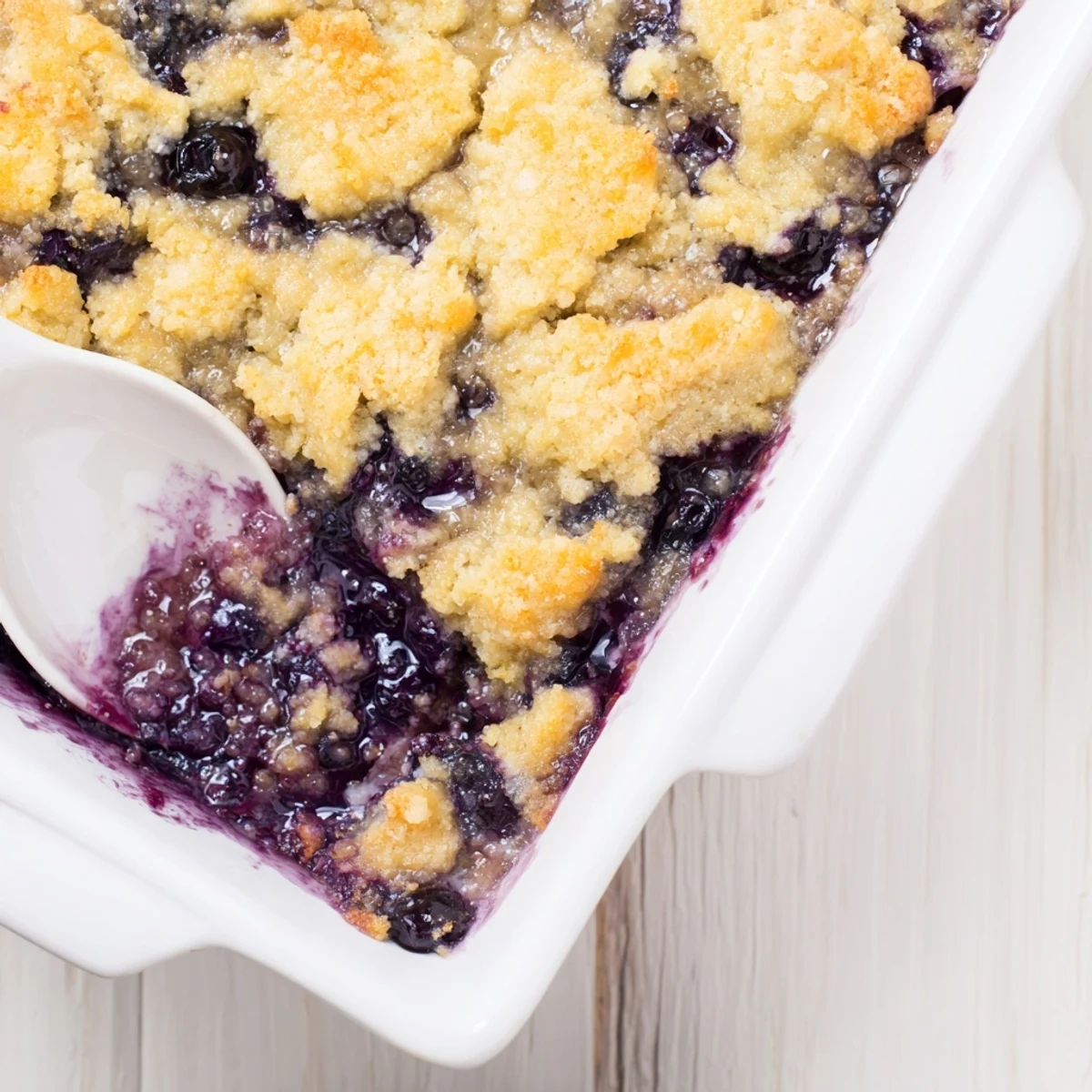 Close-up of Moist Blueberry Cobbler With Frozen Berries, golden biscuit crust over bubbling blueberry filling, served warm.