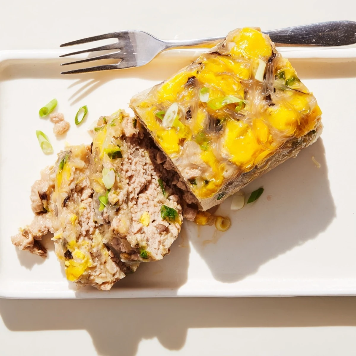 Steamed Cha Trung Hap topped with glossy egg yolk, garnished with scallions and ready to enjoy with pickled vegetables.