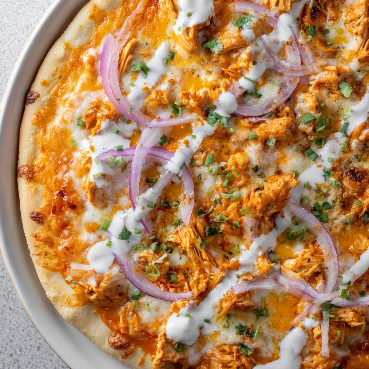 Sizzling hot Bold Buffalo Chicken Pizza cut into slices, revealing a golden crust and creamy ranch base perfect for game day.