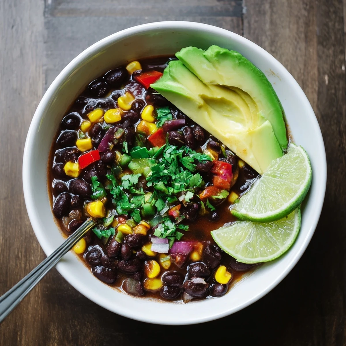 A close-up of Black Bean Corn Chili Lime Delight served with a side of crunchy tortilla chips.