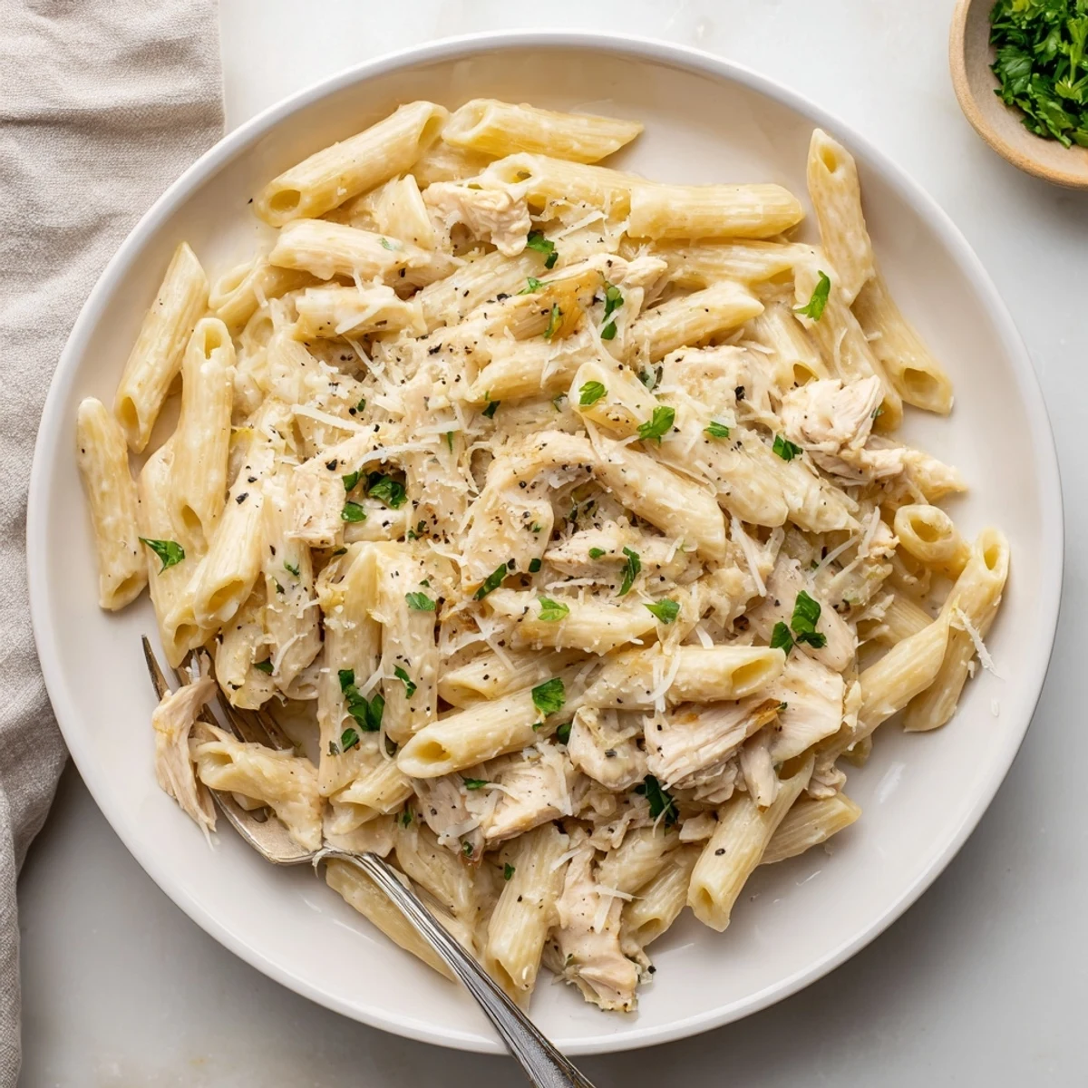Tender shredded chicken in creamy garlic Parmesan sauce coats penne pasta in this Crockpot Garlic Parmesan Chicken Pasta.