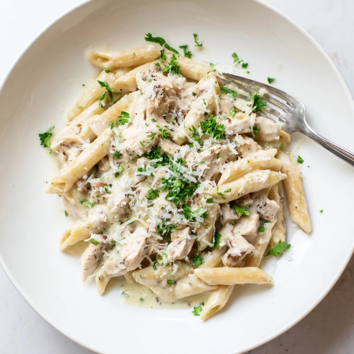 This Crockpot Garlic Parmesan Chicken Pasta is topped with fresh parsley and served hot for a cozy dinner.