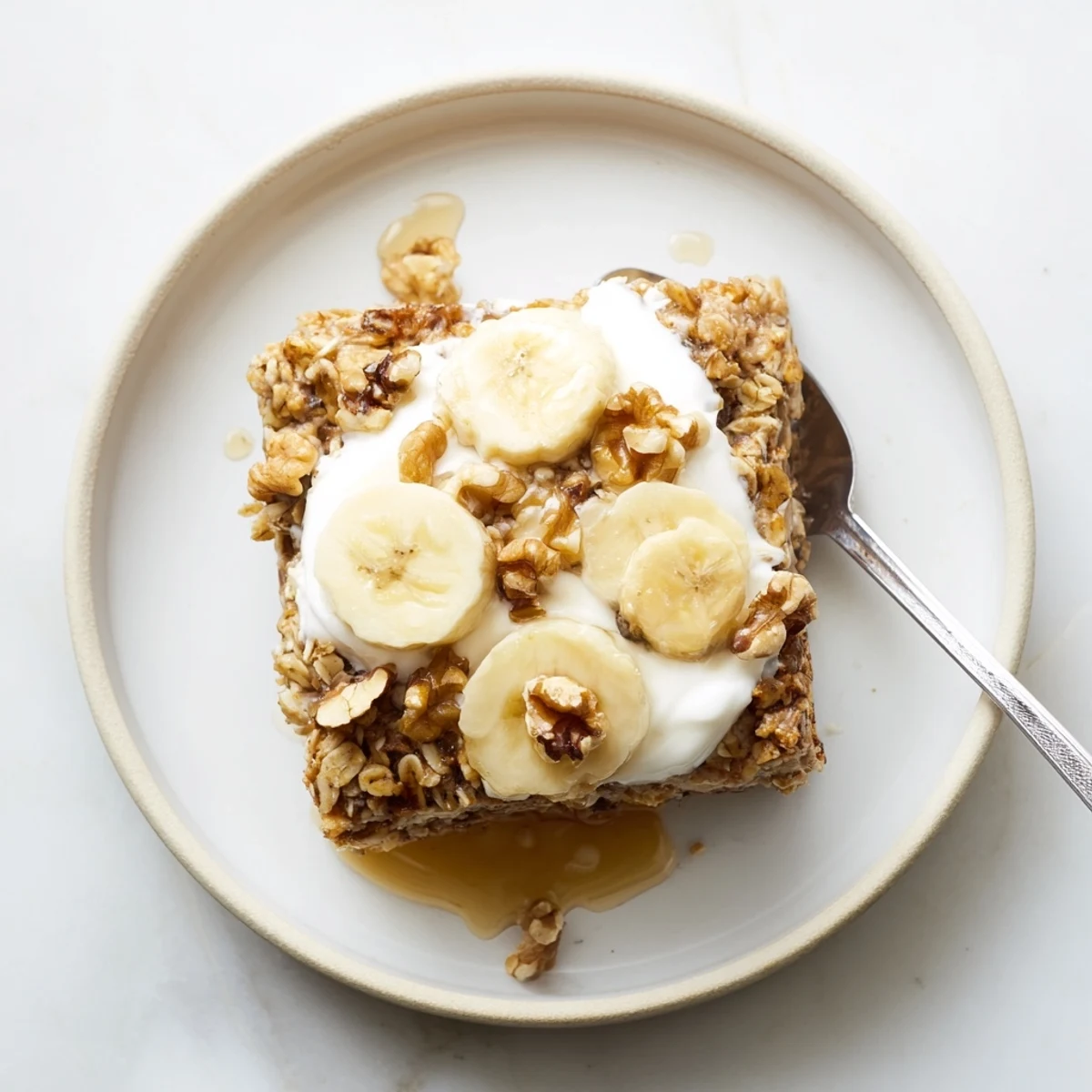 Freshly baked Banana Baked Oatmeal with Greek Yogurt cooling on a wire rack, showing golden edges.