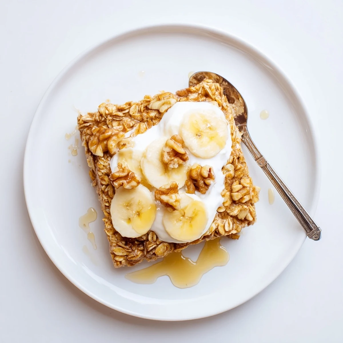 The golden-brown Banana Baked Oatmeal with Greek Yogurt served in a white dish, perfect for a cozy morning.