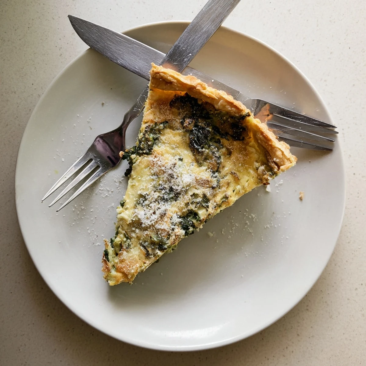 Golden egg pie with silverbeet and ricotta featuring a flaky buttery pastry crust and golden parmesan topping