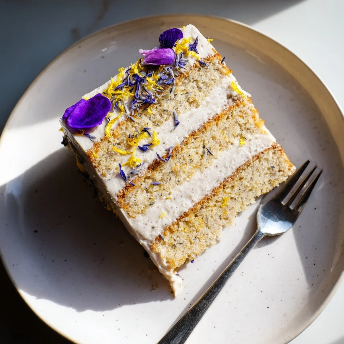 Three-layer London Fog cake with creamy vanilla bean frosting and elegant edible flowers