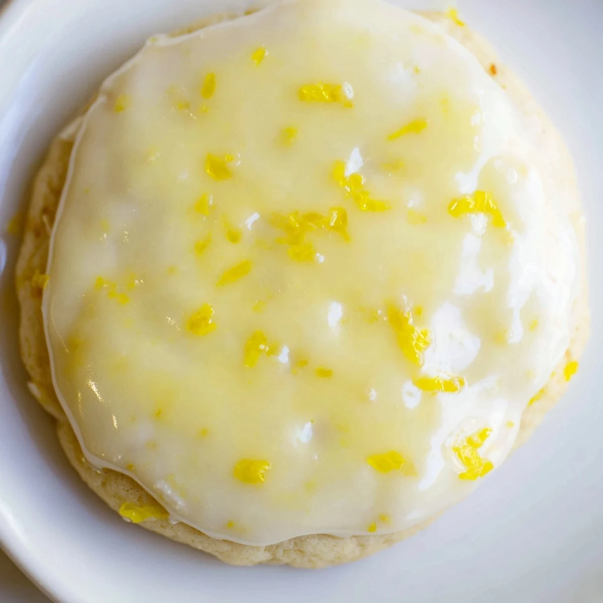 Golden buttery lemon cookies drizzled with sweet citrus frosting cooling on wire rack