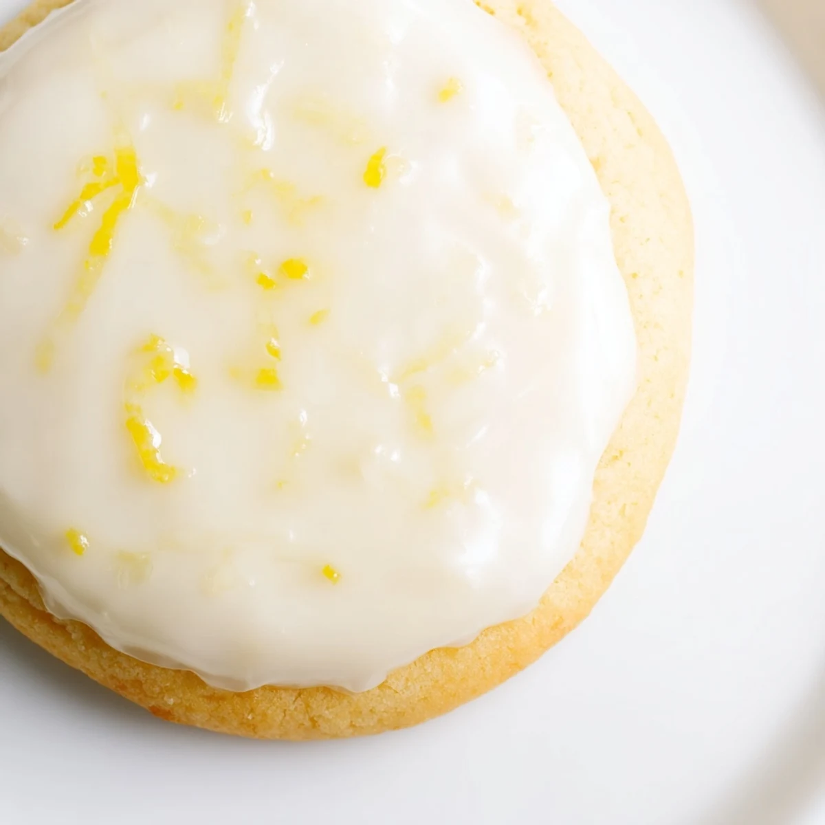Batch of bright lemon frosted cookies arranged on wooden board with powdered sugar dusting