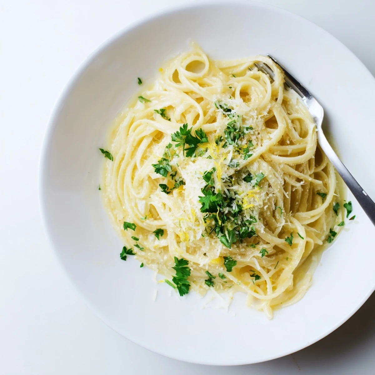 Close up of one pot garlic butter pasta twirled on fork with grated cheese