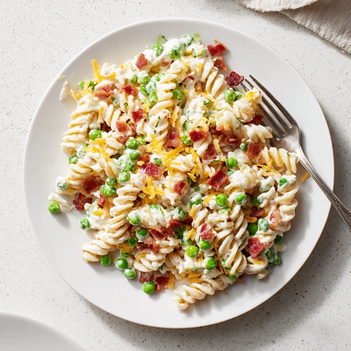 Cold pasta salad with rotini noodles tossed in tangy dressing with bacon crumbles