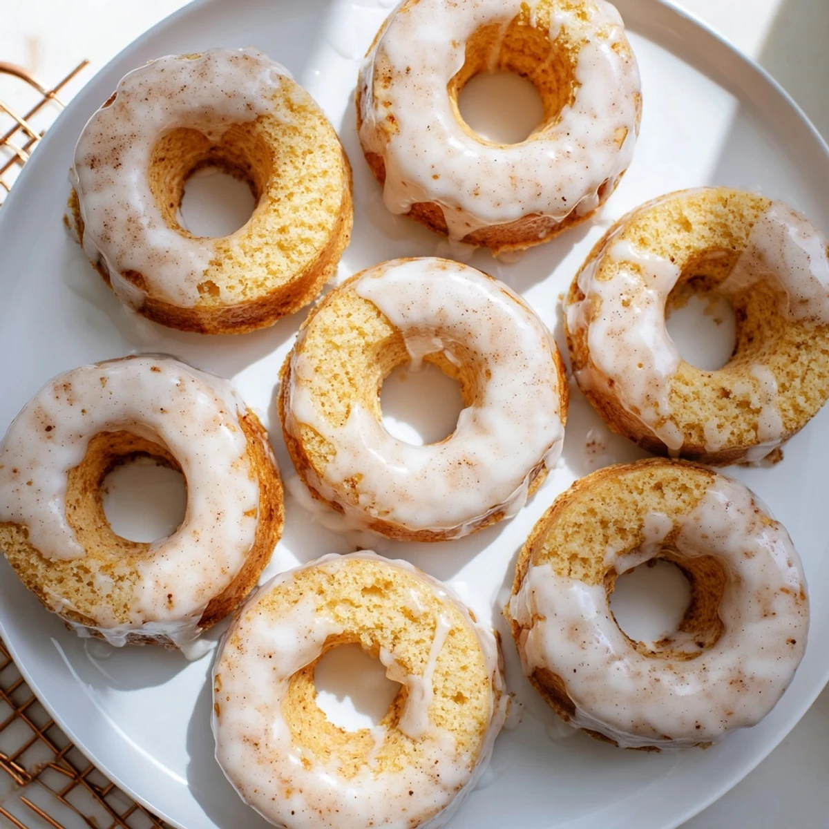 Moist Greek yogurt cake donuts arranged on a serving tray with powdered sugar dusting