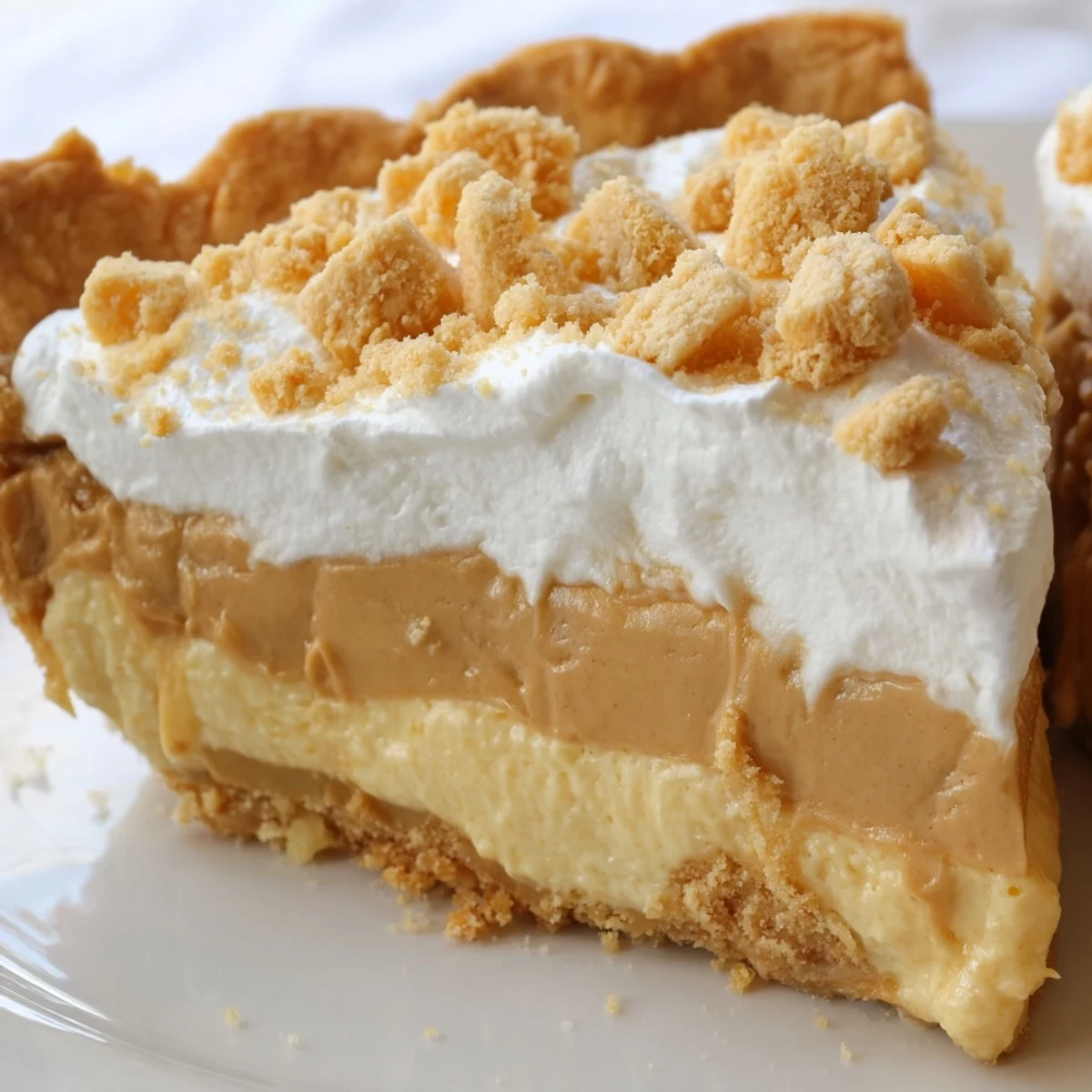Creamy Old Fashioned Amish Peanut Butter Dream Pie topped with fluffy whipped cream and golden crumbs