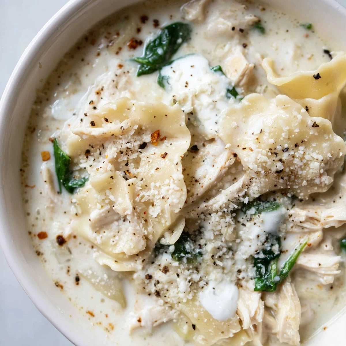Creamy white lasagna soup with tender chicken and melted cheese in a bowl