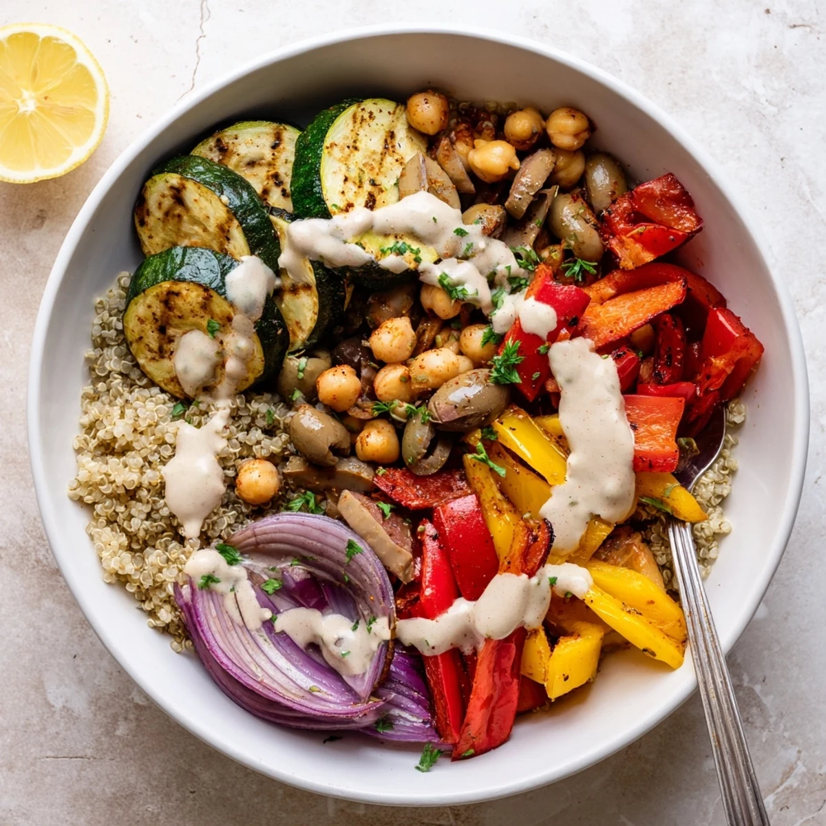 Golden roasted zucchini, eggplant, and chickpeas in a vegan Mediterranean roasted vegetables bowl drizzled with creamy tahini dressing.