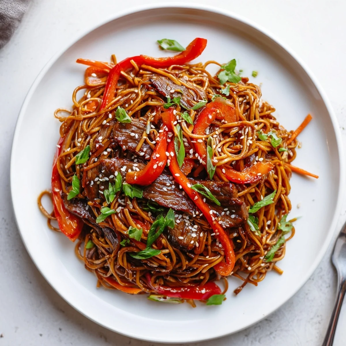 Steaming bowl of Sticky Beef Noodles with glossy honey-hoisin glaze and sesame seeds