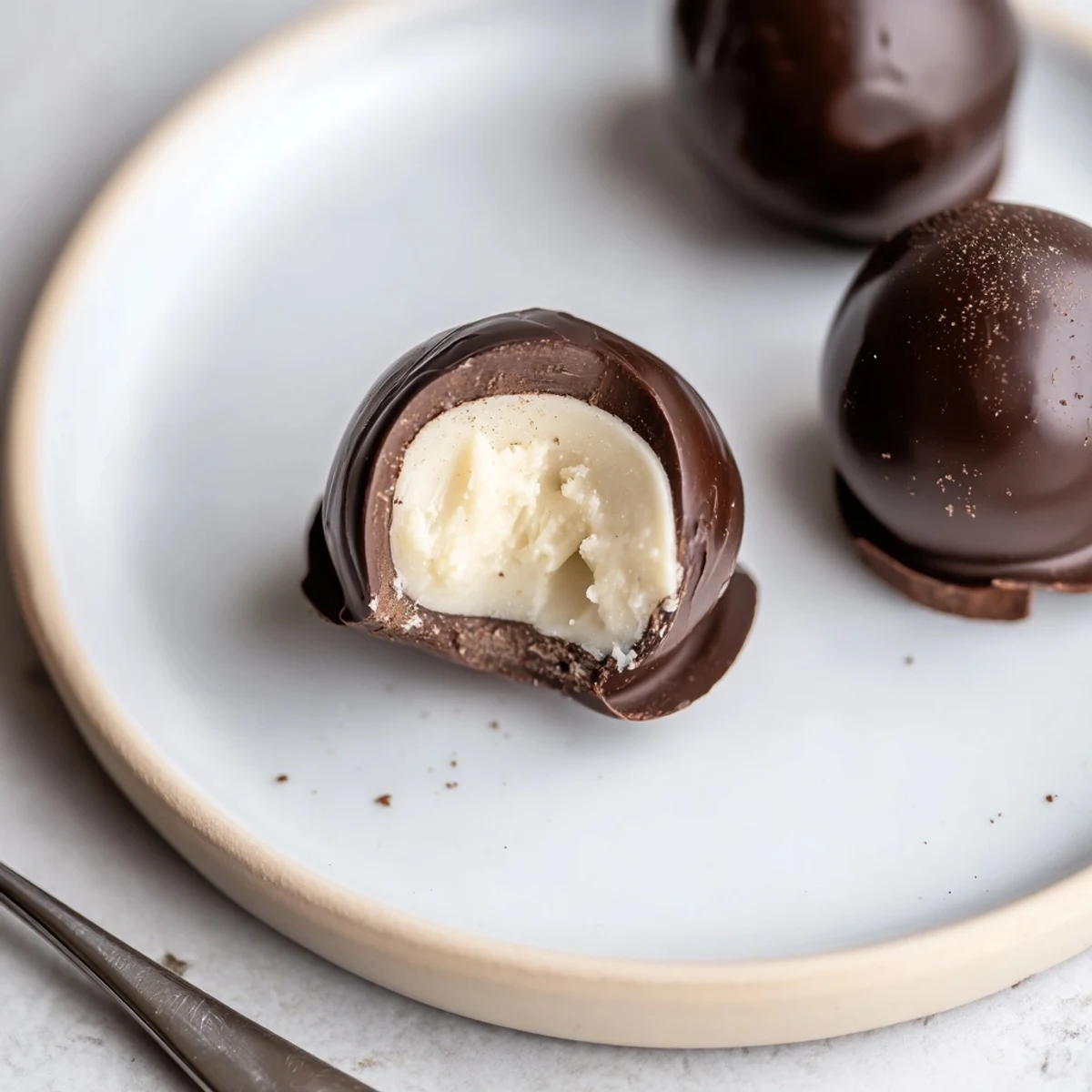 Dark Chocolate Eggnog Truffles with glossy shells and creamy spiced centers
