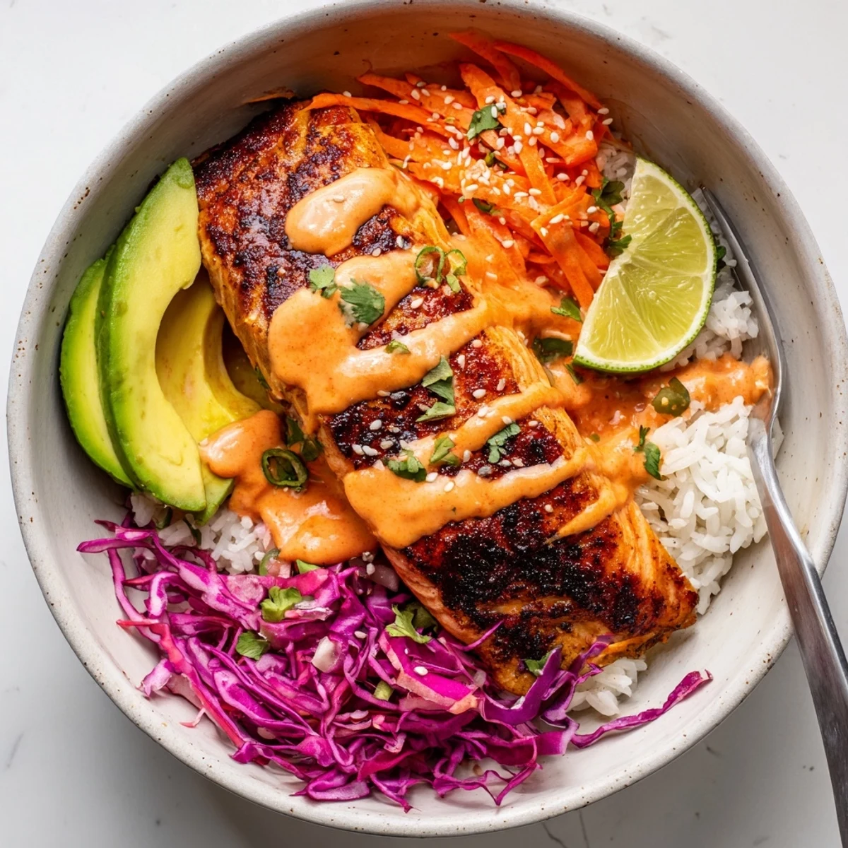A colorful Bang Bang Salmon Bowls: jasmine rice, crunchy cabbage, zesty lime