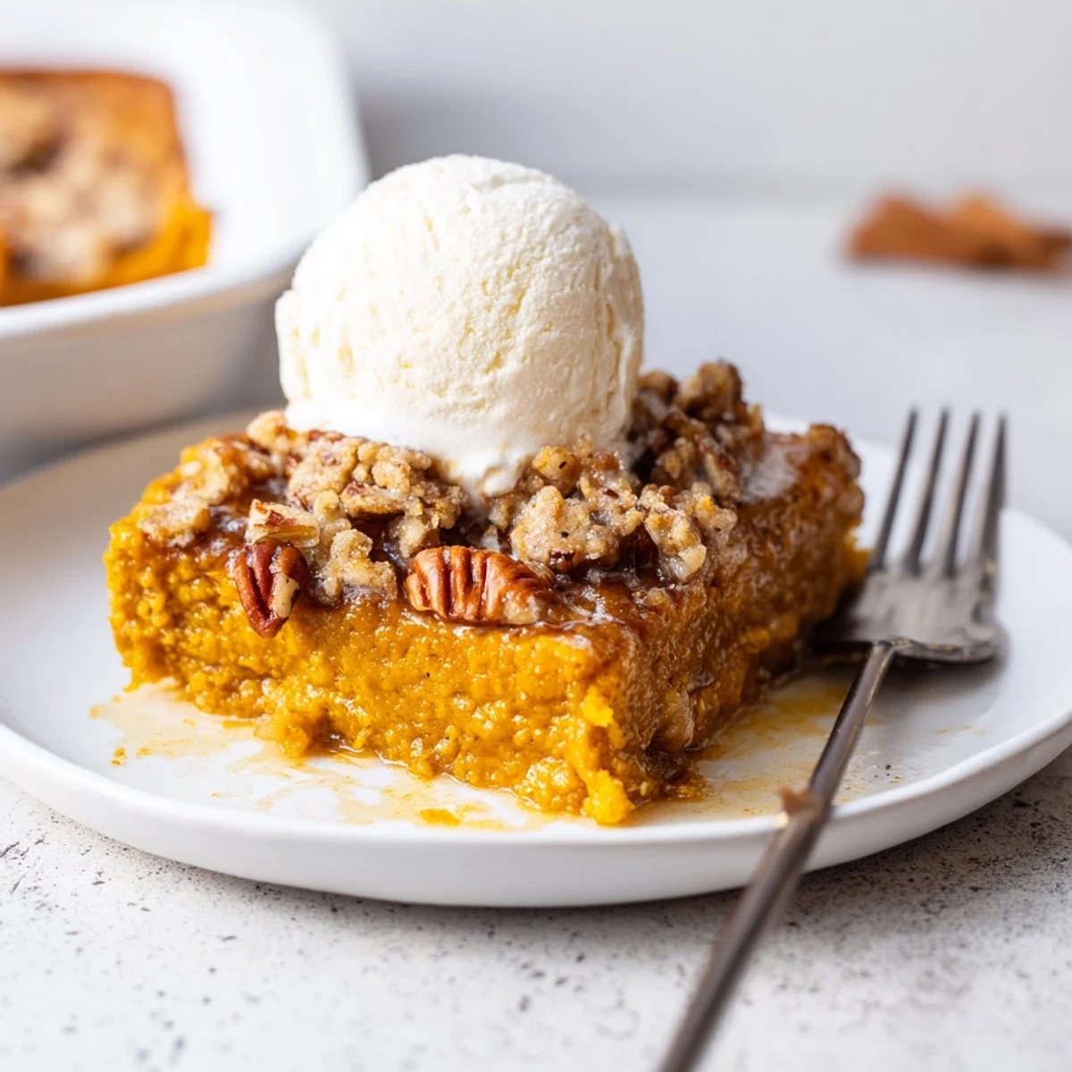 Homemade Pumpkin Dump Cake served warm with whipped cream and spice