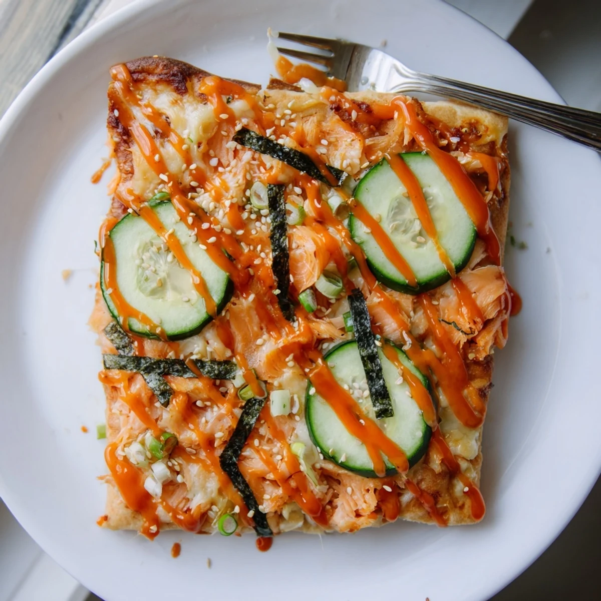 Salmon Sushi Bake Flatbread Pizza With Spicy Drizzle oozing melted cheese, bright cucumber slices