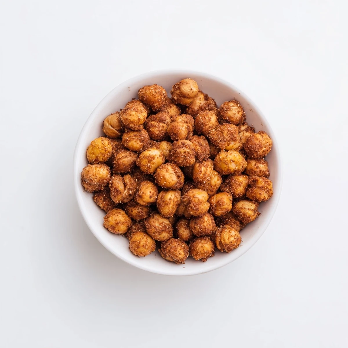 Golden brown cinnamon roasted chickpeas sprinkled with coconut sugar on a parchment lined baking sheet
