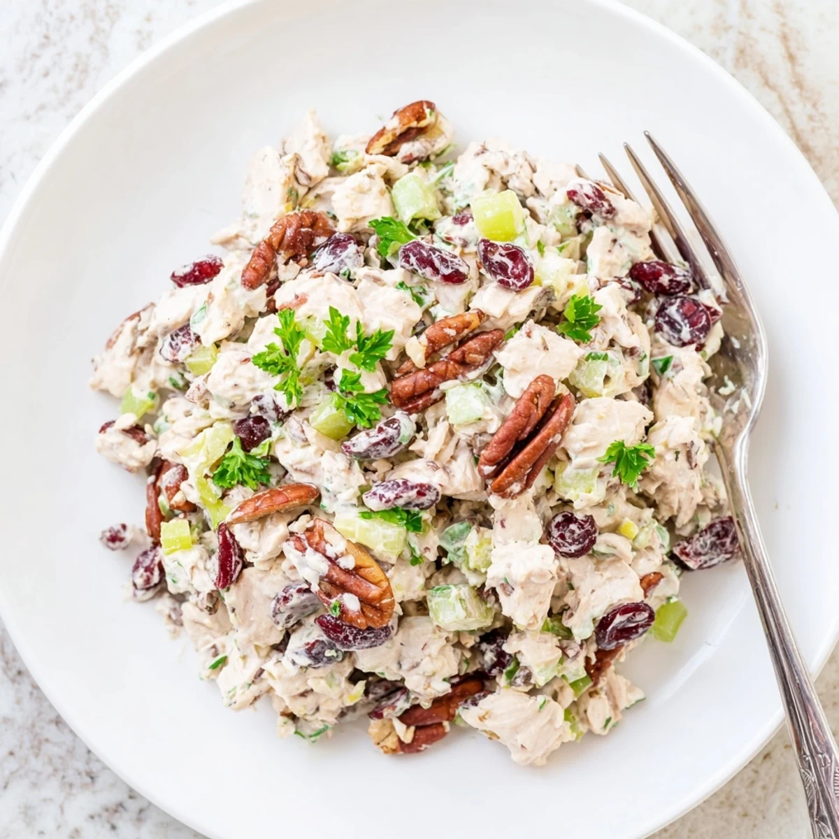 Close-up of cranberry pecan chicken salad showcasing toasted nuts and creamy dressing coating