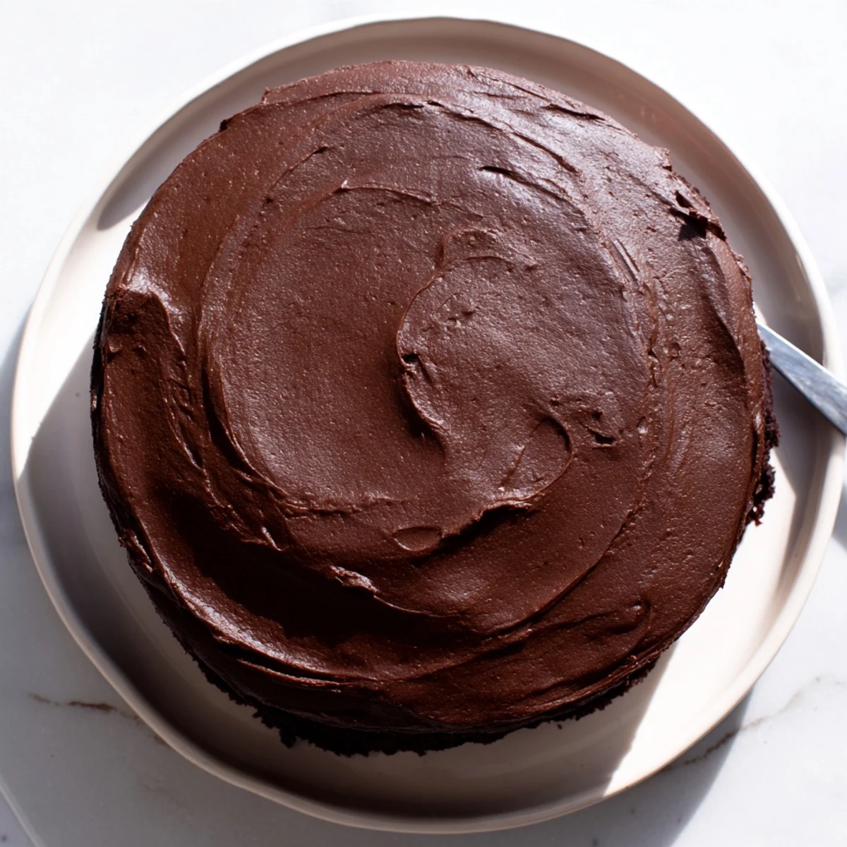 Matildas Chocolate Cake served on white plate with thick chocolate ganache dripping down sides