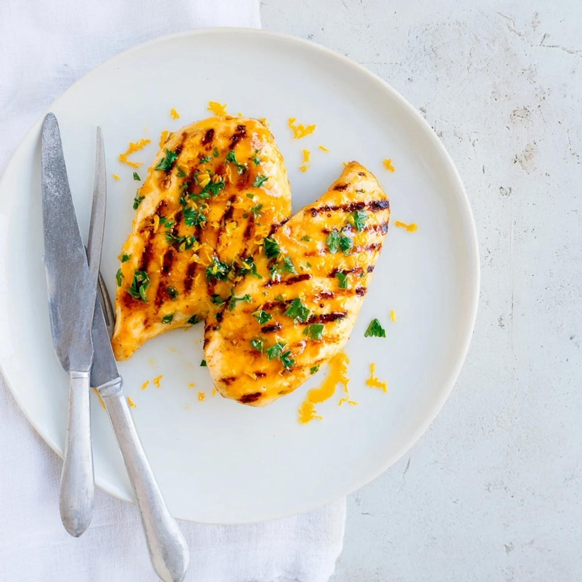 Perfectly grilled chicken with tangy orange mustard marinade served on a white dinner plate