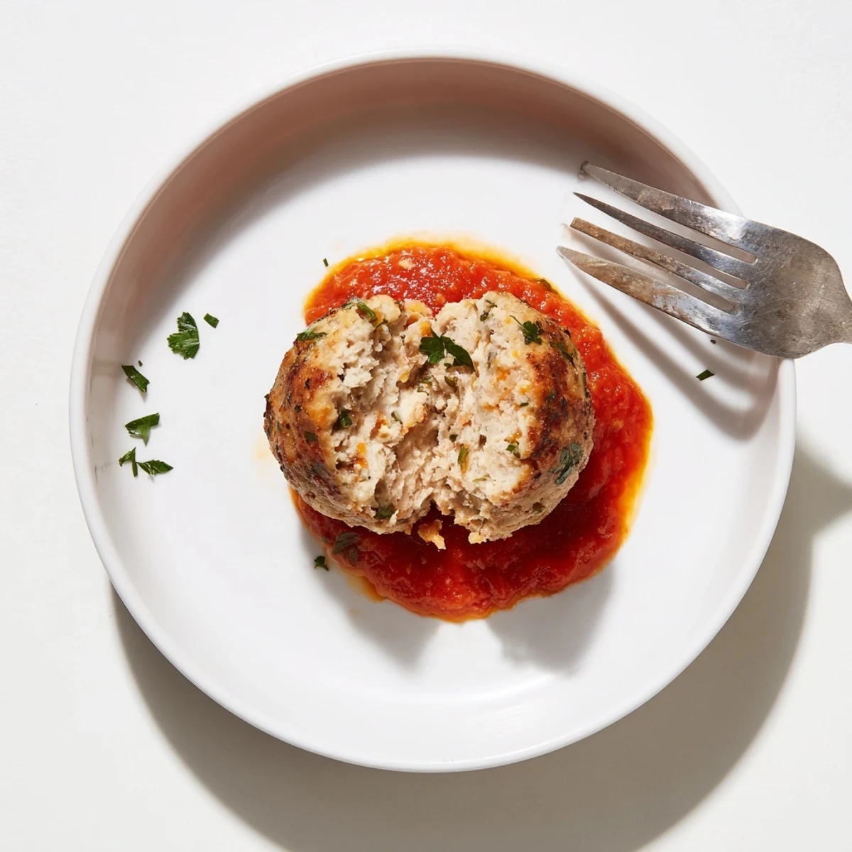 Juicy Chicken Meatballs glistening golden-brown on a baking sheet, fresh parsley  
