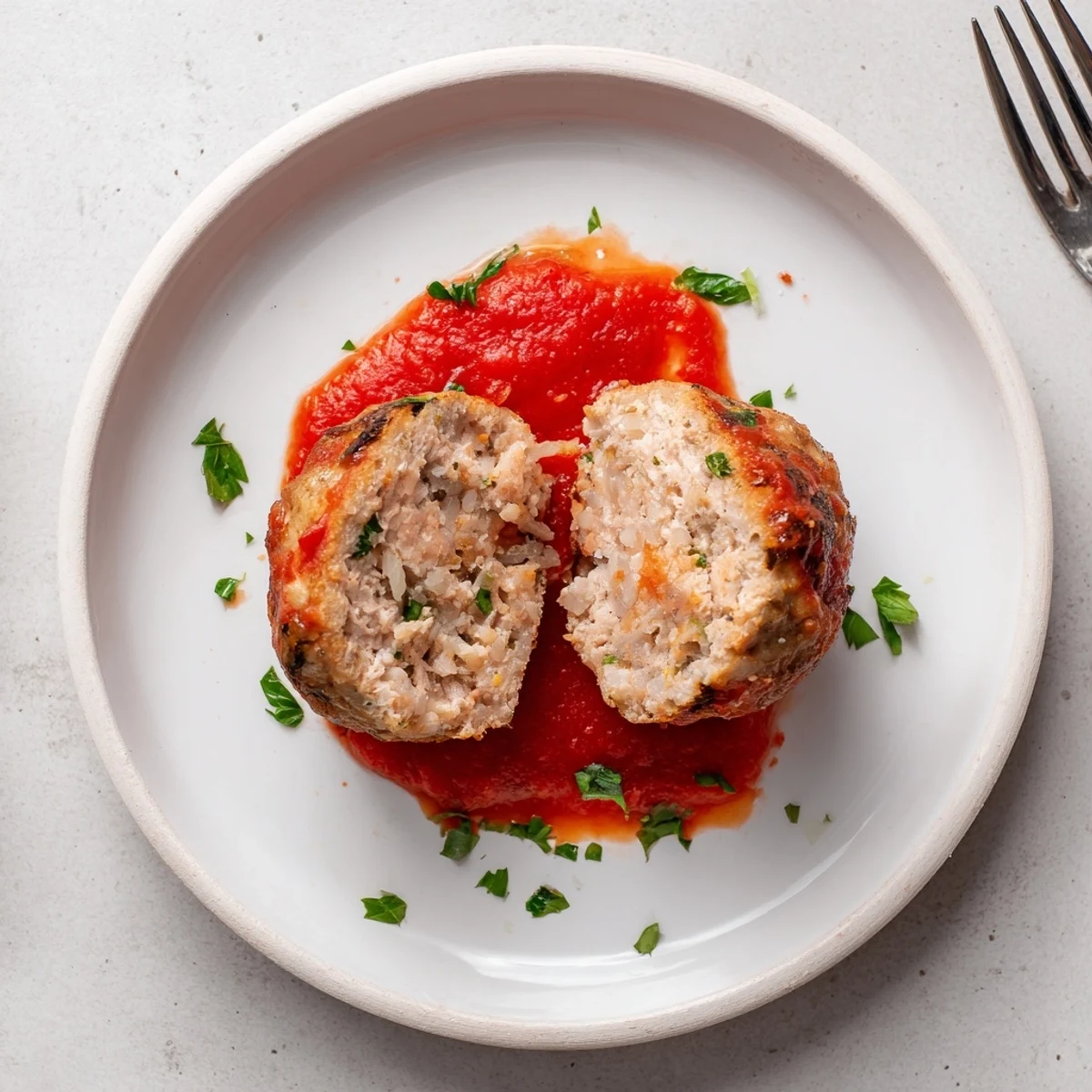 Baked Juicy Chicken Meatballs steaming, moist centers shown next to marinara  