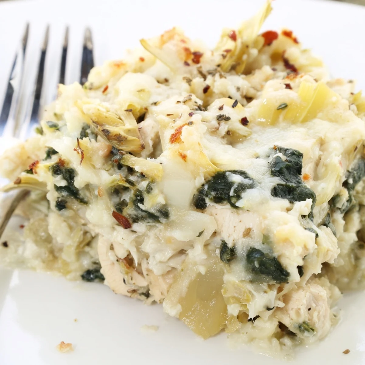 Golden-bubbly Spinach Artichoke Chicken Casserole steaming, cheesy top and juicy layers