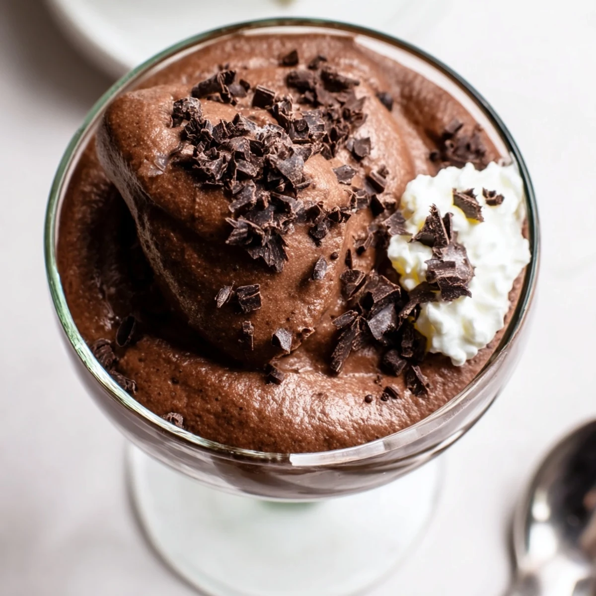 Velvety chocolate mousse served in elegant glasses topped with curly chocolate shavings