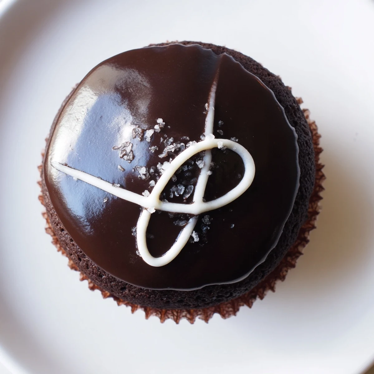 Homemade Hostess Cupcakes topped with glossy chocolate ganache and a classic white swirl