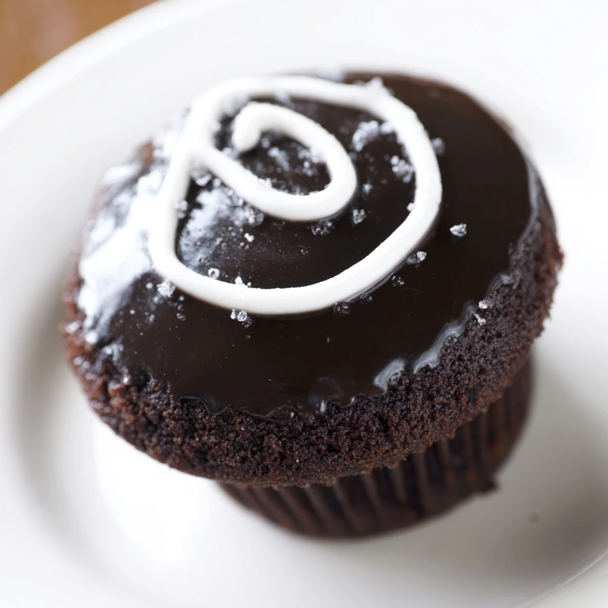 Homemade Hostess Cupcakes arranged on a wire rack with rich ganache dripping over edges