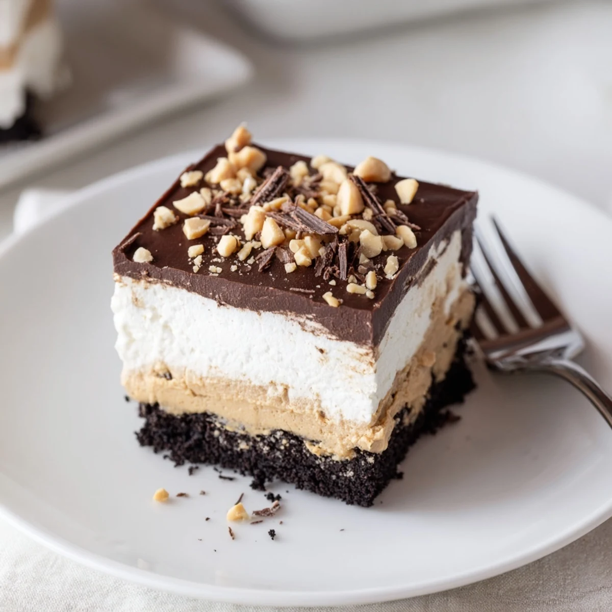 Peanut butter layered delight topped with whipped cream and chopped roasted peanuts