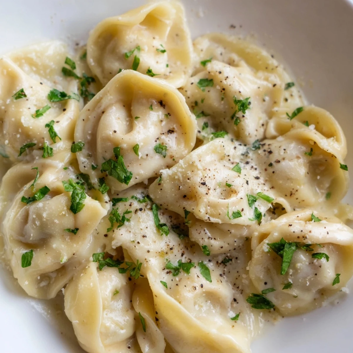 Creamy chicken tortellini draped in rich Parmesan sauce with fresh parsley garnish