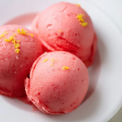Refreshing Strawberry Lemonade Sorbet in a clear glass, showing its smooth texture and bright, summery pink hue.  