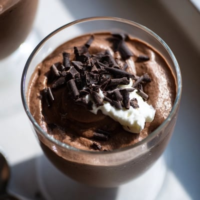 Silky chocolate mousse spooned into crystal dessert cups with a dollop of whipped cream