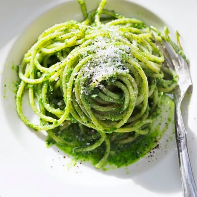 Wild garlic pesto pasta twirled into nests and garnished with cracked black pepper